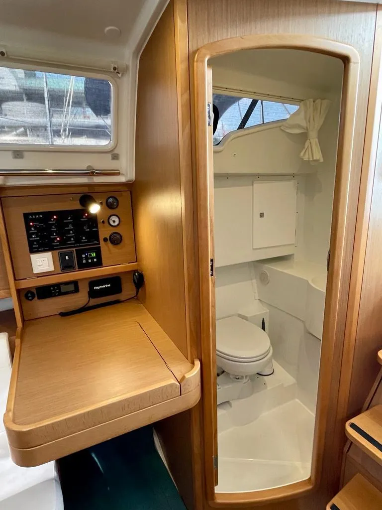 Slide: The Image of 2021 Jeanneau Sun Odyssey 319 interior with compact bathroom and navigation panel. - 8