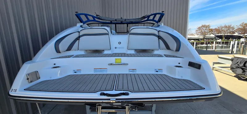 Slide: The Image of 2020 Yamaha Boats AR240, rear view, docked, showcasing spacious deck and seating. - 11