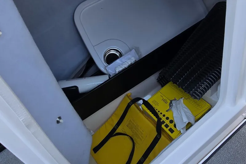 Slide: The Image of Storage compartment in a 2020 Yamaha AR240 boat with various items. - 12