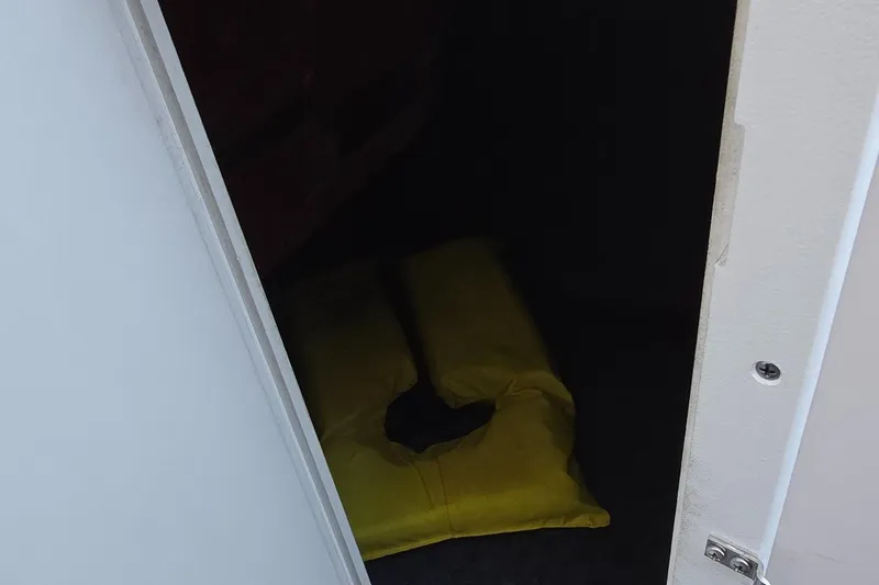 Slide: The Image of Open storage compartment in 2020 Yamaha AR240 boat with yellow cushion inside. - 13