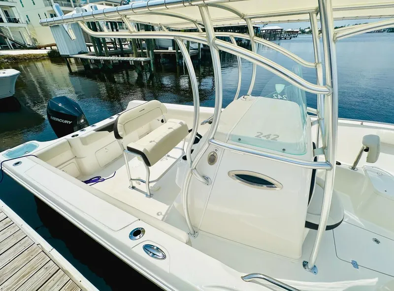 Slide: The Image of 2022 Sailfish 242 CC boat docked, featuring sleek design and Mercury outboard motor. - 10