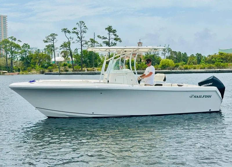Slide: The Image of 2022 Sailfish 242 CC boat on calm water with trees in the background. - 11