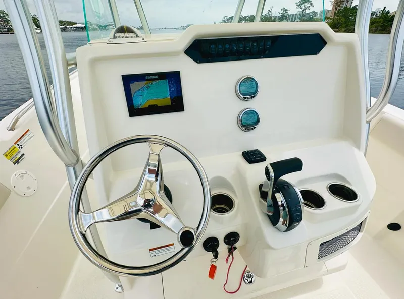 Slide: The Image of 2022 Sailfish 242 CC boat console with steering wheel, controls, and navigation display. - 14