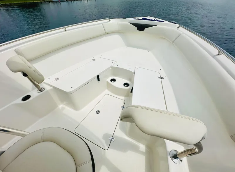 Slide: The Image of 2022 Sailfish 242 CC boat interior with white seating and storage compartments. - 18