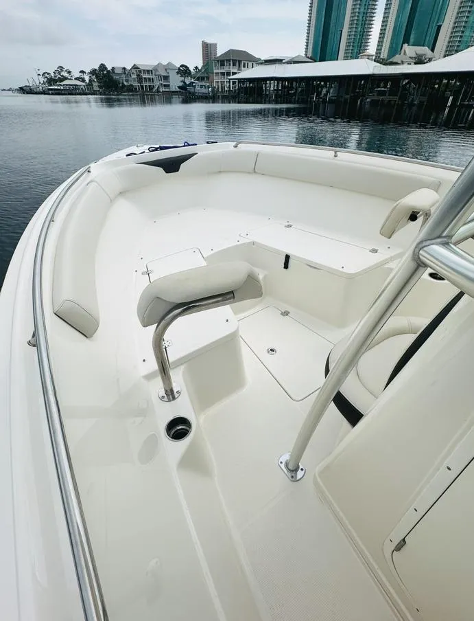 Slide: The Image of 2022 Sailfish 242 CC boat interior with white seating and waterfront view. - 19