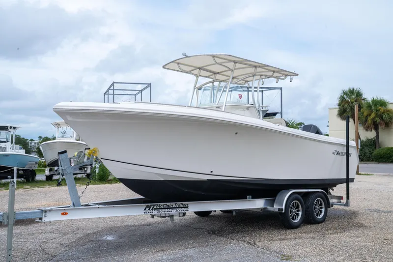 Slide: The Image of 2022 Sailfish 242 CC boat on trailer, parked outdoors under cloudy sky. - 3