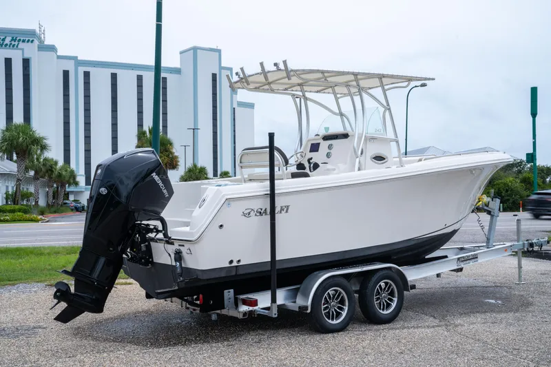 Slide: The Image of 2022 Sailfish 242 CC boat on trailer, parked near a hotel. - 4