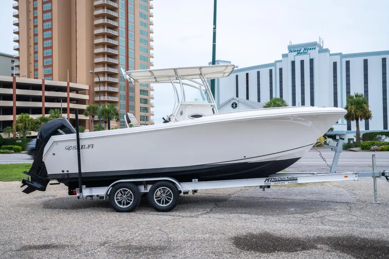 Slide: The Image of 2022 Sailfish 242 CC boat on trailer, urban background with tall buildings. - 5