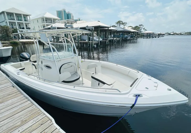 Slide: The Image of 2022 Sailfish 242 CC boat docked by waterfront homes. - 6