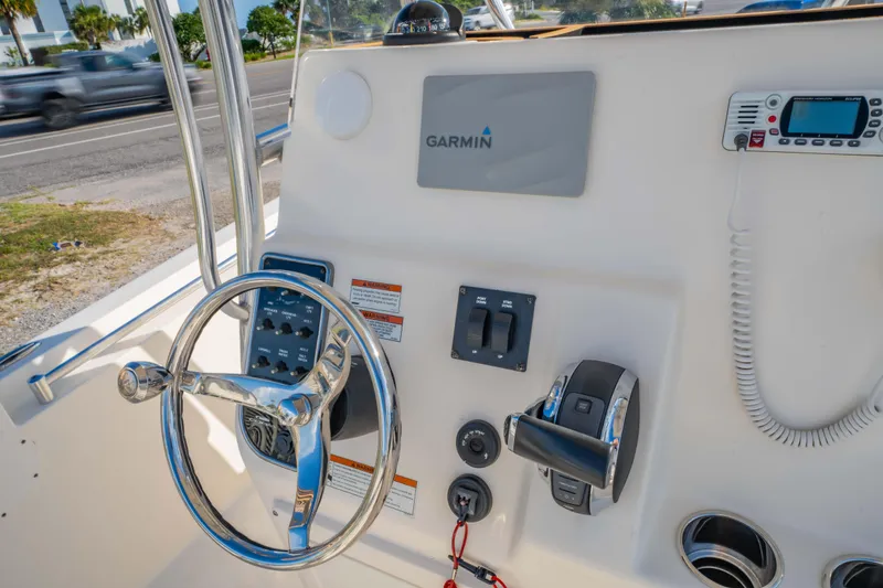 Slide: The Image of 2022 Cobia 237 CC boat dashboard with Garmin navigation system and steering wheel. - 22