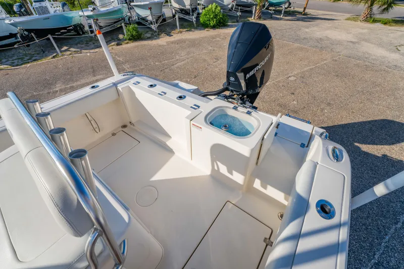 Slide: The Image of 2022 Cobia 237 CC boat on trailer with Mercury engine, under sunny sky. - 9