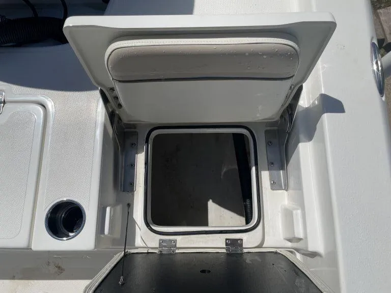 Slide: The Image of Open storage compartment on a 2015 NauticStar 2200 Sport boat with cushioned seat. - 11