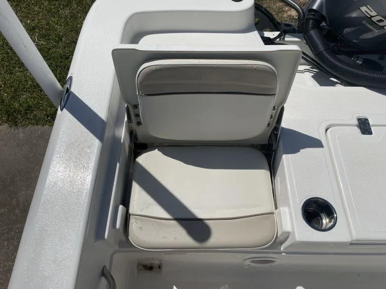 Slide: The Image of 2015 NauticStar 2200 Sport boat seat with white upholstery and cup holder. - 12