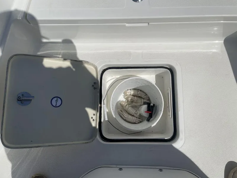 Slide: The Image of Open storage compartment on 2015 NauticStar 2200 Sport boat with coiled rope inside. - 21