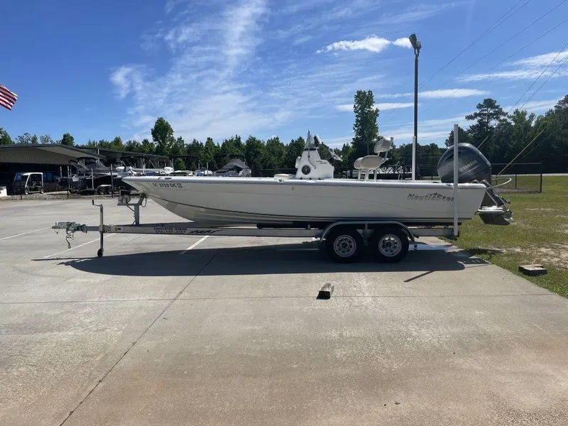 Slide: The Image of 2015 NauticStar 2200 Sport boat on trailer, parked outdoors under clear sky. - 3