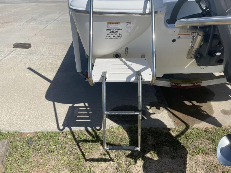 Slide: The Image of Rear view of 2015 NauticStar 2200 Sport boat with ladder extended on concrete surface. - 5