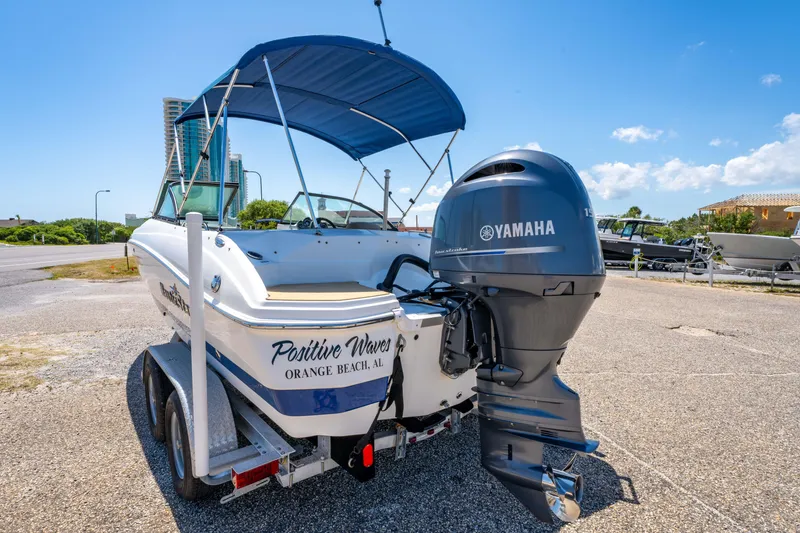 Slide: The Image of 2020 NauticStar 203 DC boat with Yamaha engine on trailer, blue canopy, sunny day. - 11