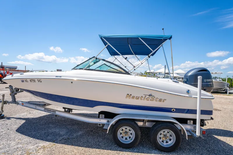 Slide: The Image of 2020 NauticStar 203 DC boat on trailer under clear blue sky. - 12