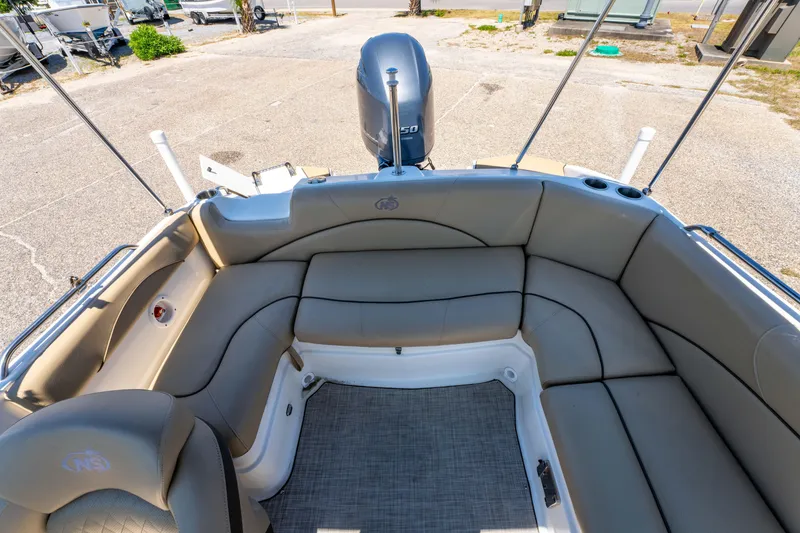 Slide: The Image of 2020 NauticStar 203 DC boat interior with spacious seating and outboard motor. - 14