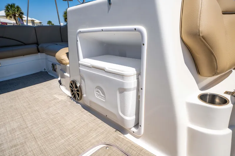 Slide: The Image of 2020 NauticStar 203 DC boat interior with seating, cooler storage, and speaker. - 20