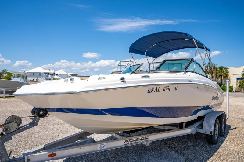 Slide: The Image of 2020 NauticStar 203 DC boat on trailer with blue canopy under clear sky. - 3