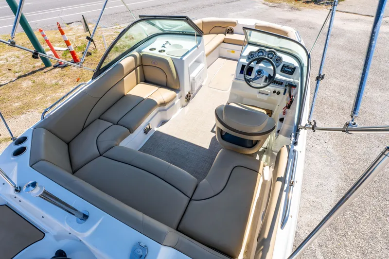 Slide: The Image of 2020 NauticStar 203 DC boat interior with beige seating and modern dashboard. - 5