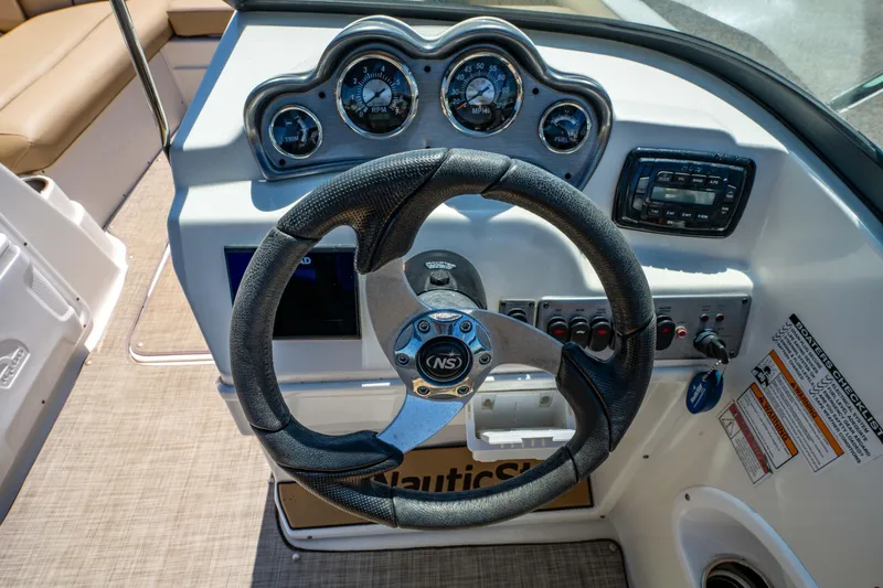 Slide: The Image of Steering wheel and dashboard of 2020 NauticStar 203 DC boat, featuring gauges and controls. - 7