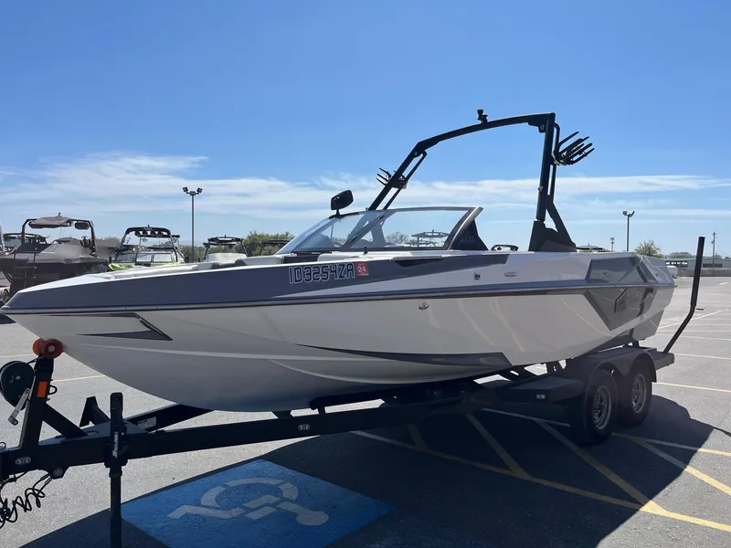 Slide: The Image of 2021 Axis T22 boat on trailer in parking lot under clear blue sky. - 10