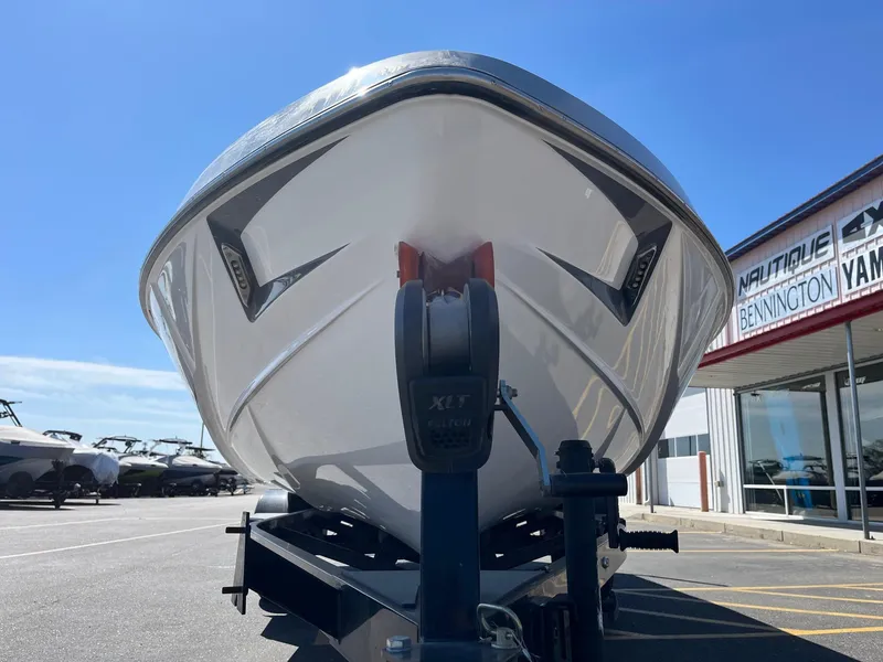 Slide: The Image of 2021 Axis T22 boat on trailer at dealership under clear blue sky. - 12