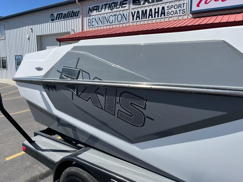 Slide: The Image of 2021 Axis T22 boat side view at dealership with brand signage. - 15