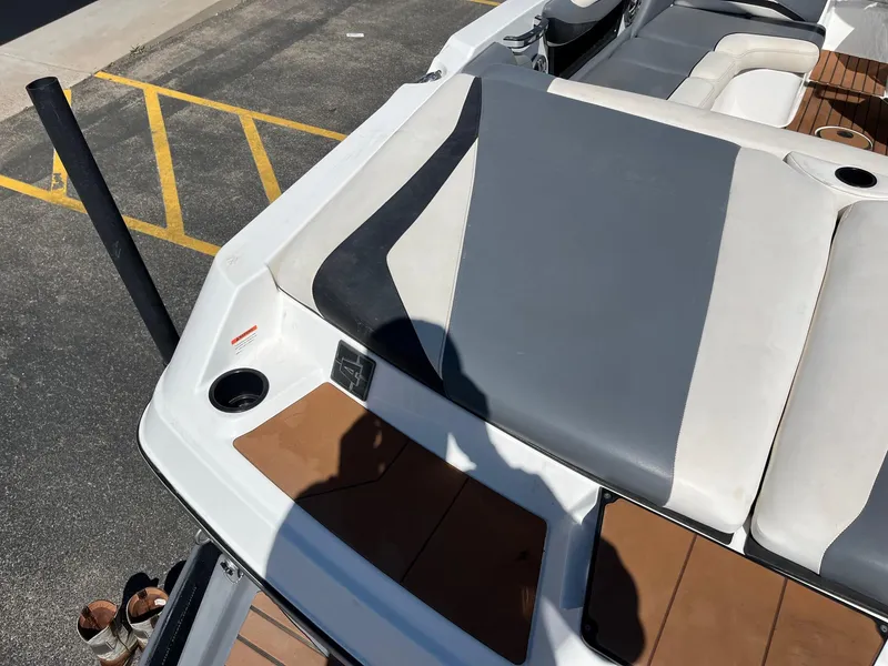 Slide: The Image of 2021 Axis T22 boat interior with gray and white seating, cup holders, and teak flooring. - 17