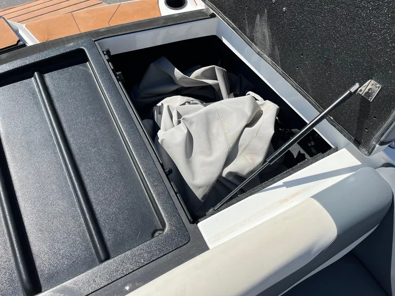 Slide: The Image of Open storage compartment on a 2021 Axis T22 boat, showing interior contents. - 34