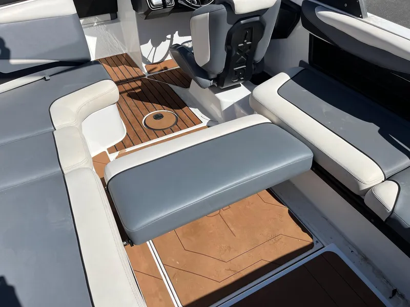 Slide: The Image of 2021 Axis T22 boat interior with gray and white seating, brown flooring. - 37