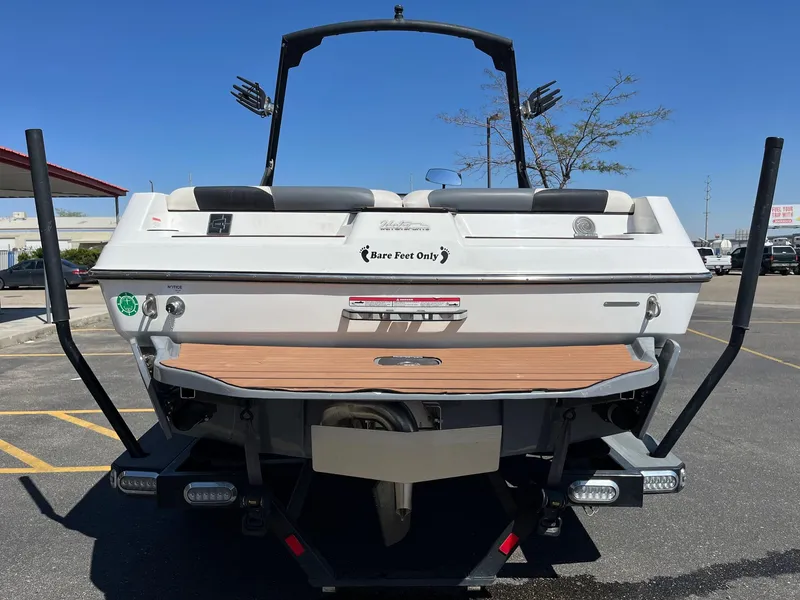 Slide: The Image of 2021 Axis T22 boat rear view in parking lot, featuring "Bare Feet Only" decal. - 5