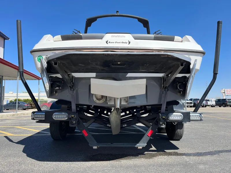 Slide: The Image of 2021 Axis T22 boat on trailer, rear view, parked in lot under clear blue sky. - 6