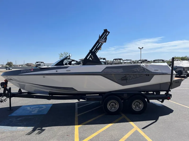 Slide: The Image of 2021 Axis T22 boat on trailer in parking lot under clear blue sky. - 9