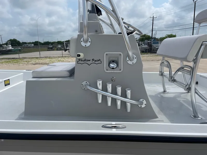 Slide: The Image of 2020 Shallow Sport 18 Sport boat console with seating and rod holders, outdoors. - 31