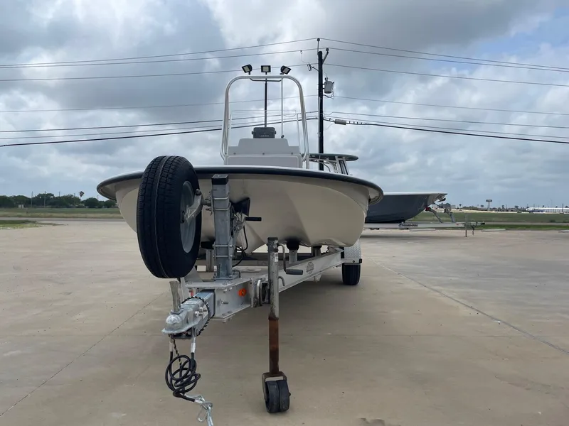 Slide: The Image of 2020 Shallow Sport 18 Sport boat on trailer, parked outdoors under cloudy sky. - 5
