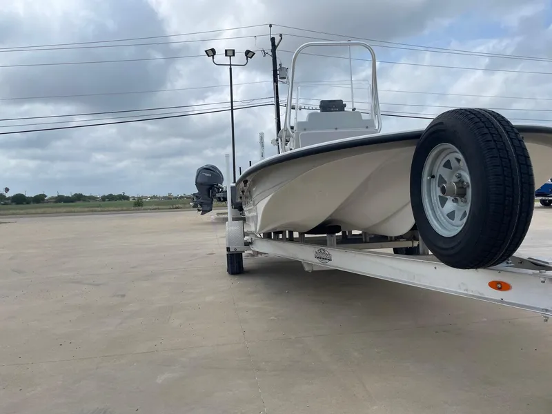 Slide: The Image of 2020 Shallow Sport 18 Sport boat on trailer, parked outdoors under cloudy sky. - 6