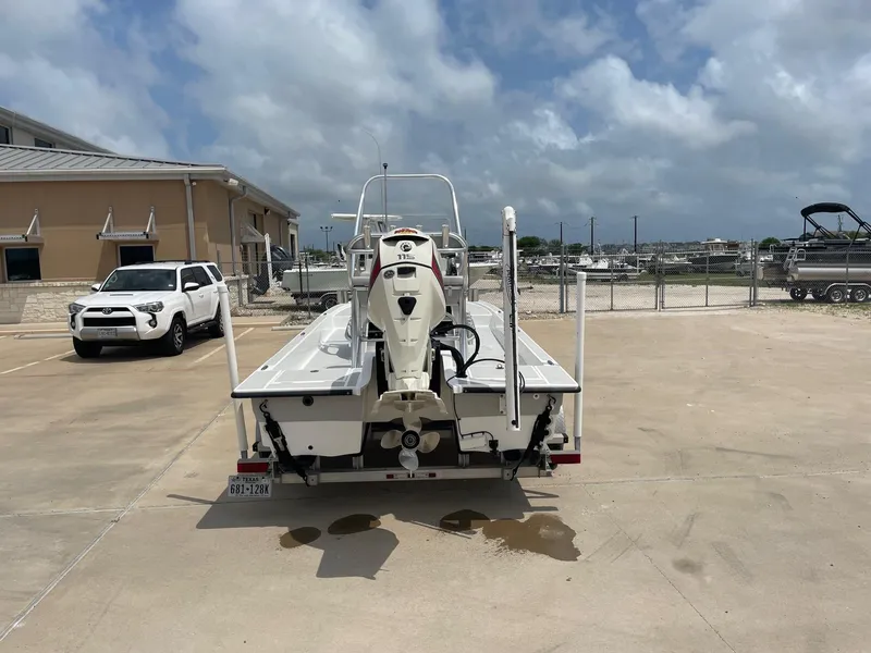 Slide: The Image of 2020 Shallow Sport 18 Sport boat parked on concrete lot under cloudy sky. - 9