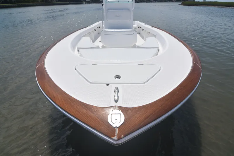Slide: The Image of 2013 Chaos 21 Tarpon Bay boat with wooden trim, docked on calm water. - 15