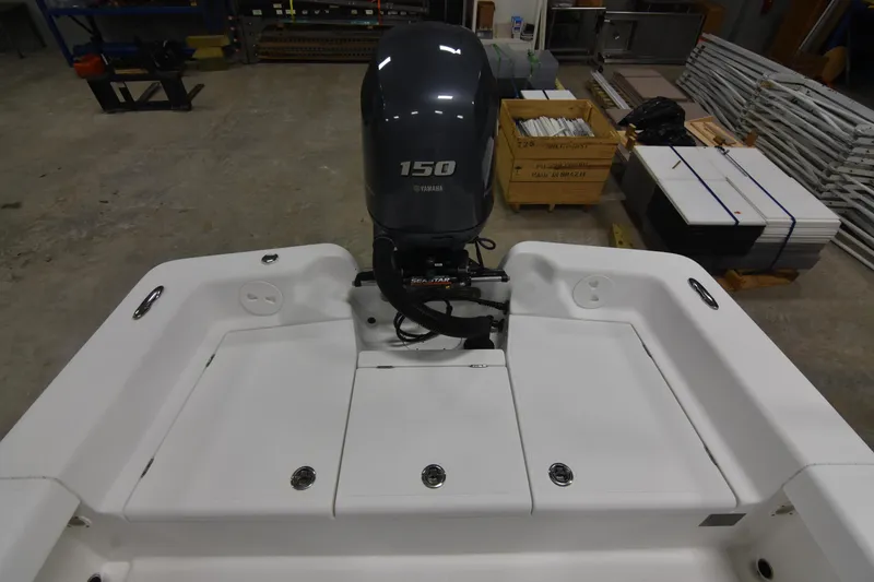 Slide: The Image of 2013 Chaos 21 Tarpon Bay boat with 150 horsepower engine in a workshop setting. - 16