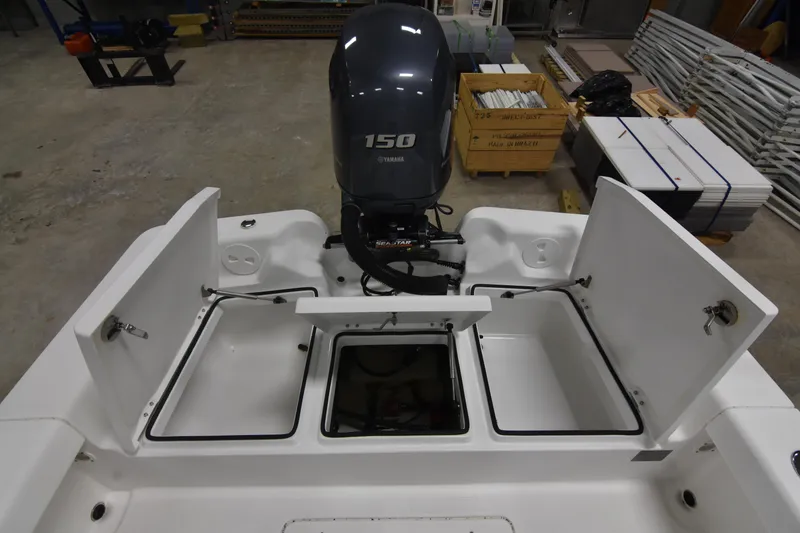 Slide: The Image of 2013 Chaos 21 Tarpon Bay boat with open storage compartments and Yamaha 150 engine. - 17