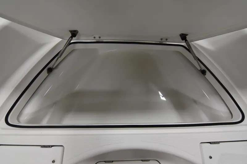 Slide: The Image of Open storage compartment of 2013 Chaos 21 Tarpon Bay boat, featuring hydraulic supports. - 21