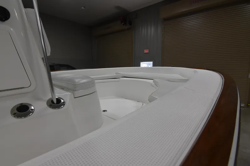 Slide: The Image of 2013 Chaos 21 Tarpon Bay boat interior with seating and rod holders in a garage. - 24