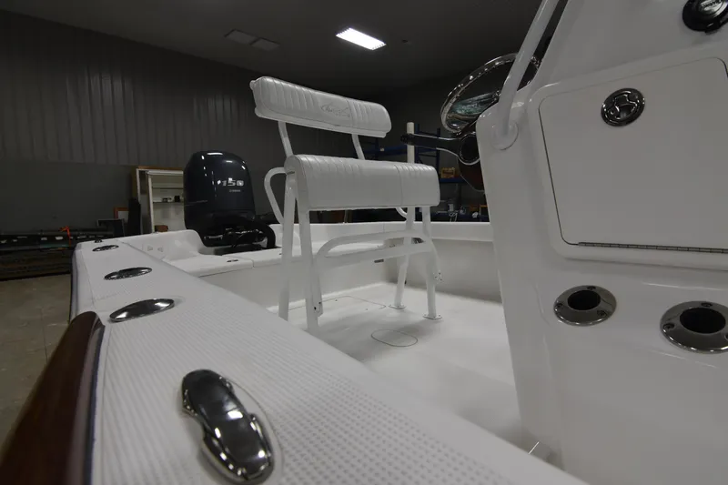 Slide: The Image of 2013 Chaos 21 Tarpon Bay boat interior with white seating and stainless steel fixtures. - 25