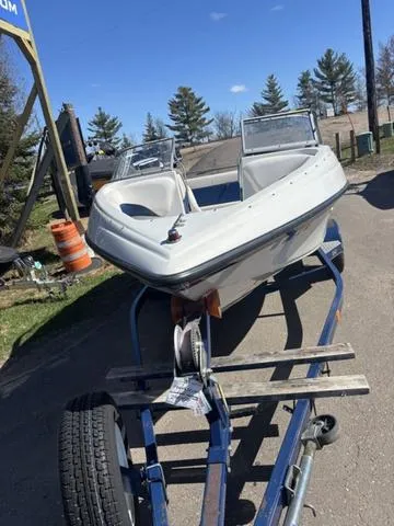 Slide: The Image of 2000 Crowline 180 BR boat on trailer, parked outdoors under clear blue sky. - 3