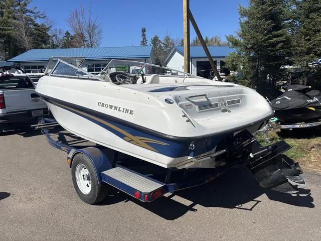 Slide: The Image of 2000 Crowline 180 BR boat on trailer, parked outdoors near trees and buildings. - 4