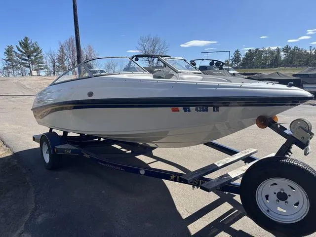 Slide: The Image of 2000 Crowline 180 BR boat on trailer, parked outdoors under clear blue sky. - 7