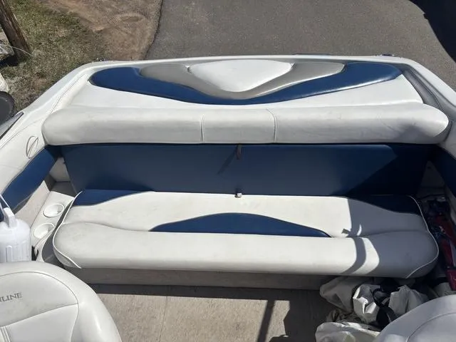 Slide: The Image of Interior seating of a 2000 Crowline 180 BR boat, featuring white and blue upholstery. - 8